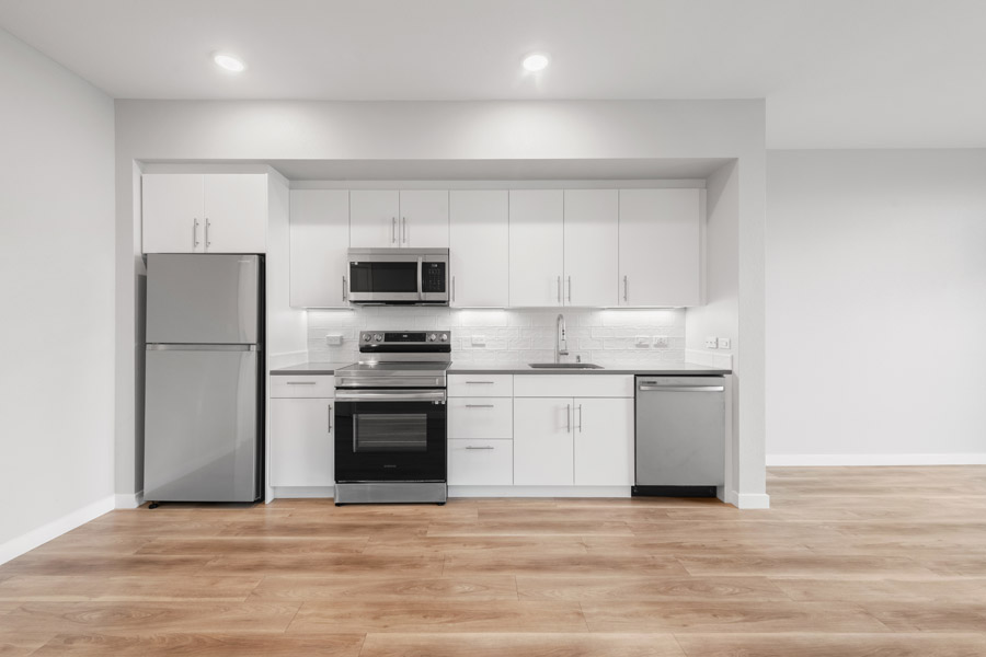 03_kitchen Modern kitchen with stainless steel appliances, white cabinetry, and open-concept layout.