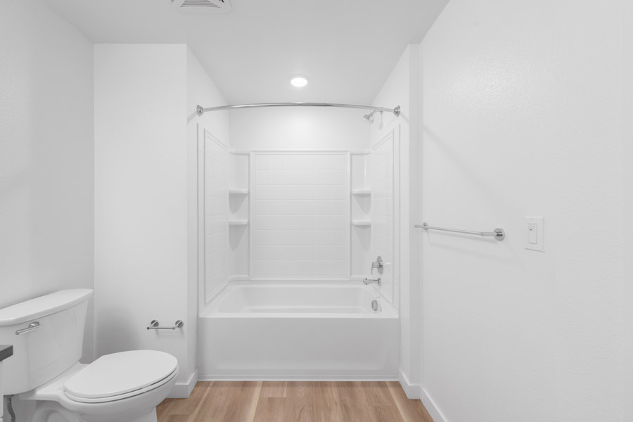 11_bath Bathroom with tub-shower combination, built-in shelving, and towel bar.