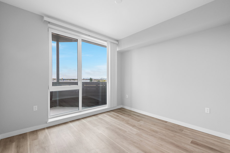 12_bedroom Bedroom with large sliding glass door, natural light, and balcony access.