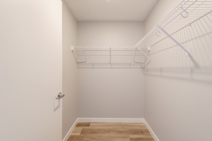 15_walk_in Walk-in closet with built-in wire shelving and wood-look flooring.