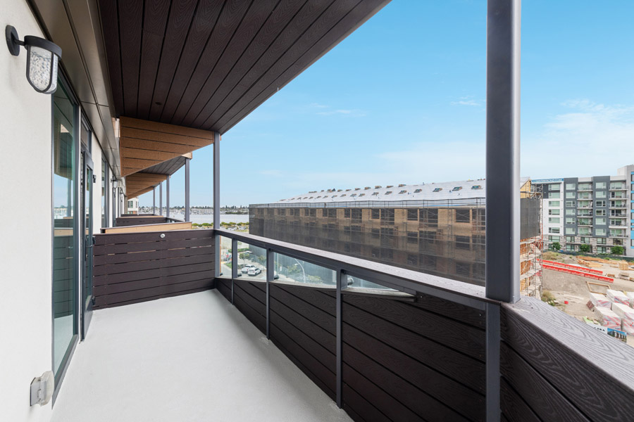 18_balcony Private balcony with glass railing and views of surrounding residential buildings.