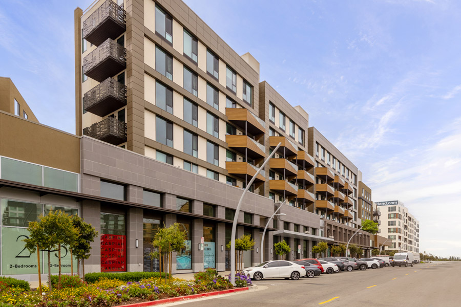 50_facade Modern condominium building exterior with private balconies and street-level retail spaces.