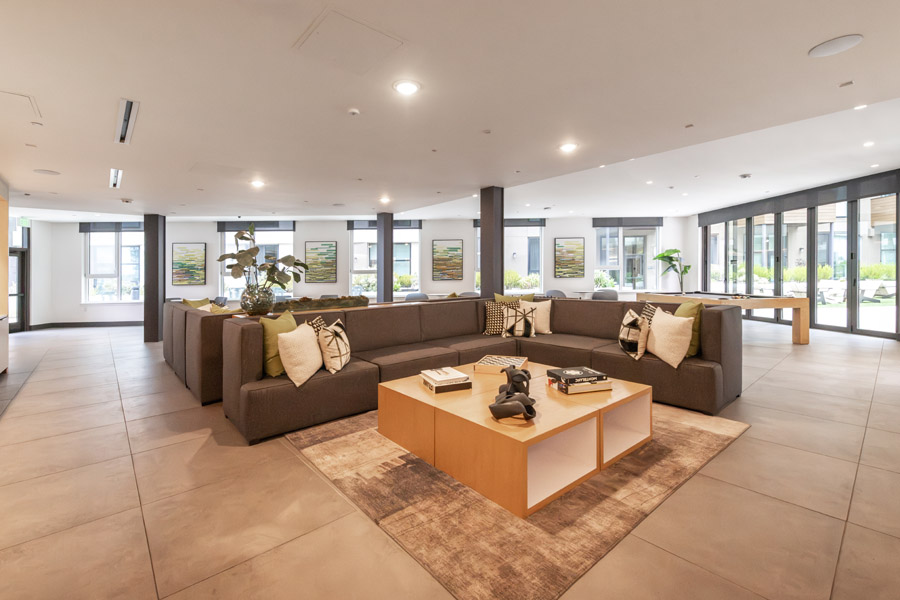 68_lounge Resident lounge with sectional seating, tables, and floor-to-ceiling windows.