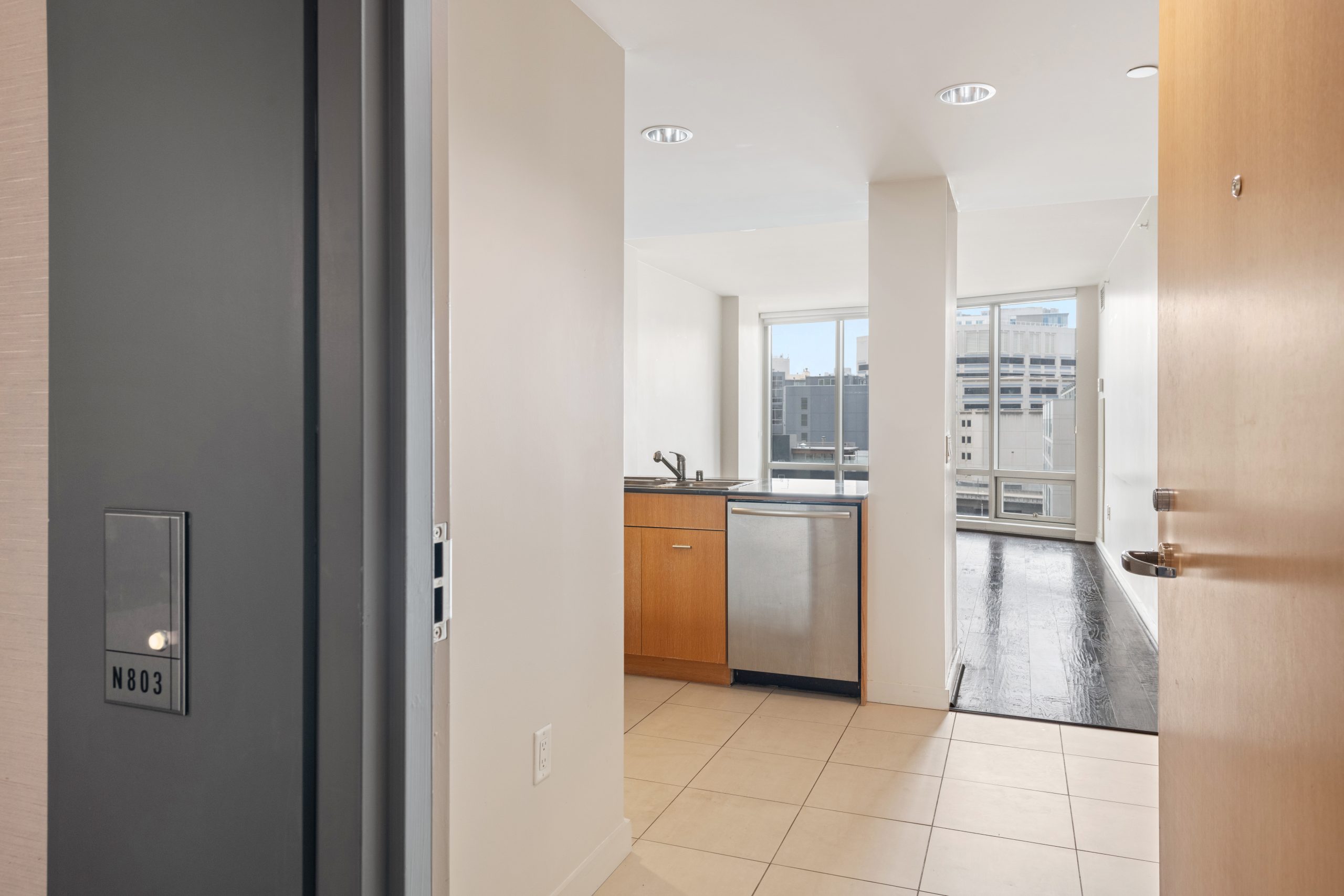 Entry hallway with tile flooring leading to kitchen and living area.