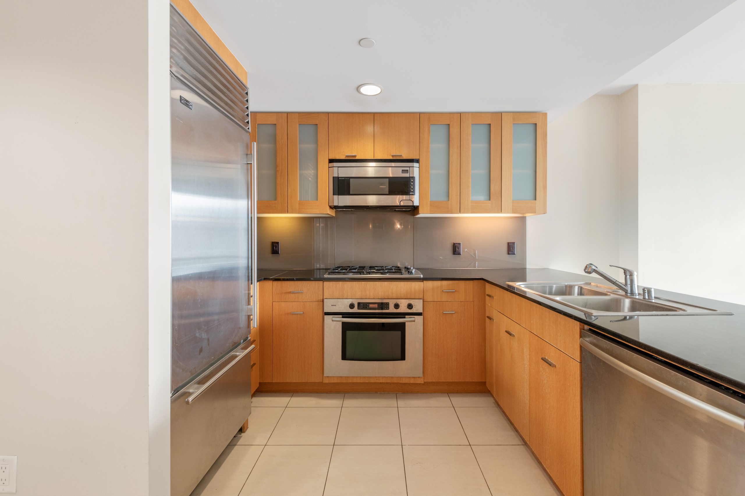 Kitchen with granite countertops, stainless steel dishwasher, and views toward the living area.