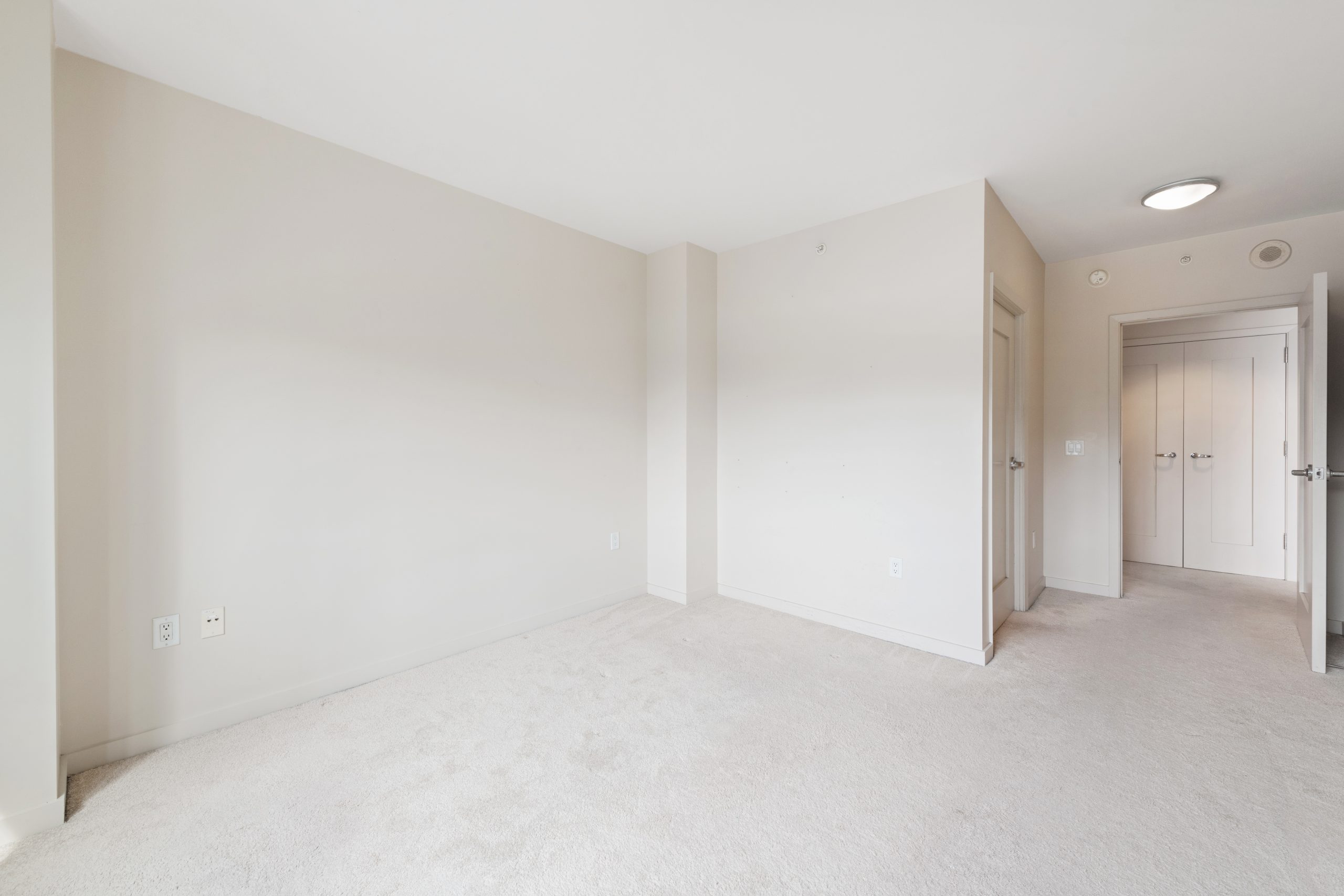 Bedroom with carpeted flooring, large window, and city views.