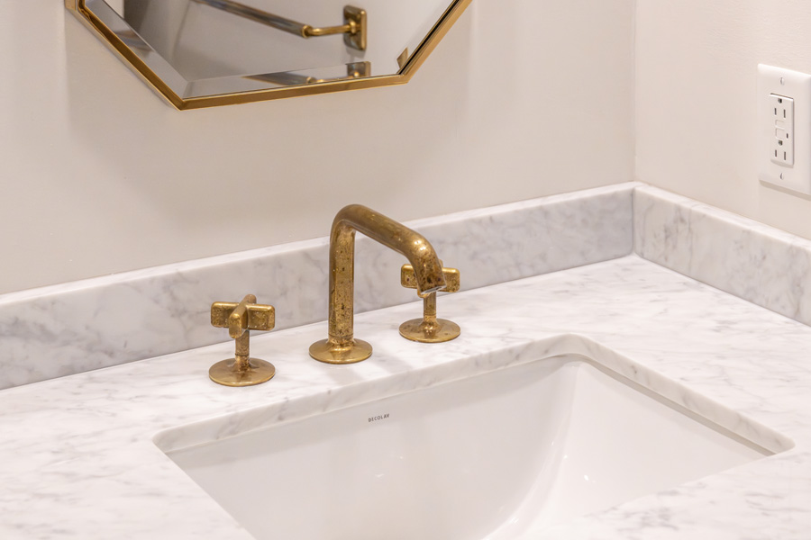 17_hallbath Bathroom with tub-shower combination, marble tile surround, and vanity sink.