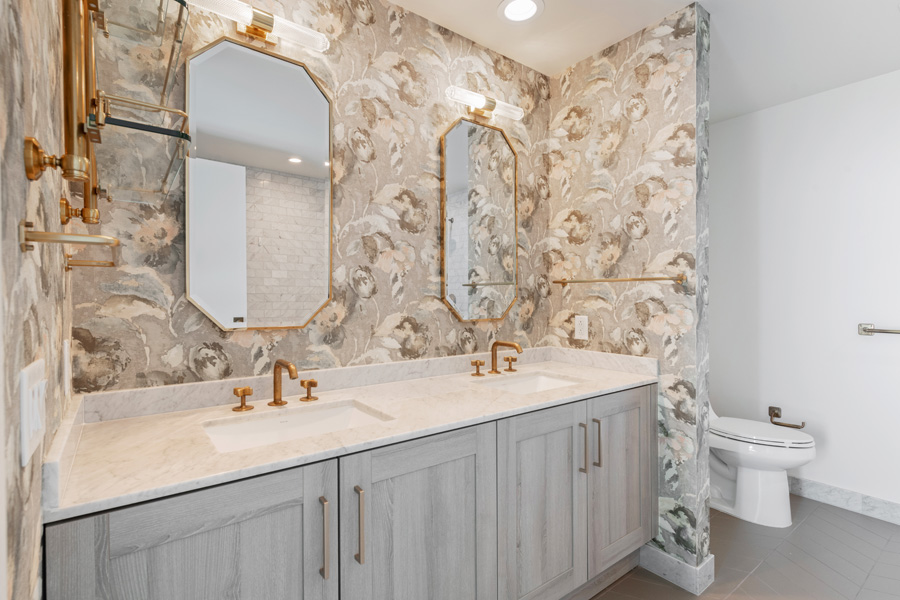 21_primary Primary bathroom with double vanity, marble countertop, and decorative wall covering.