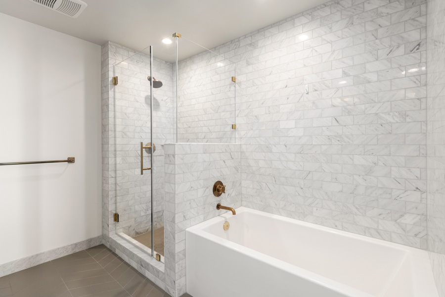22_primary Primary bathroom with glass-enclosed shower, soaking tub, and tile surround.