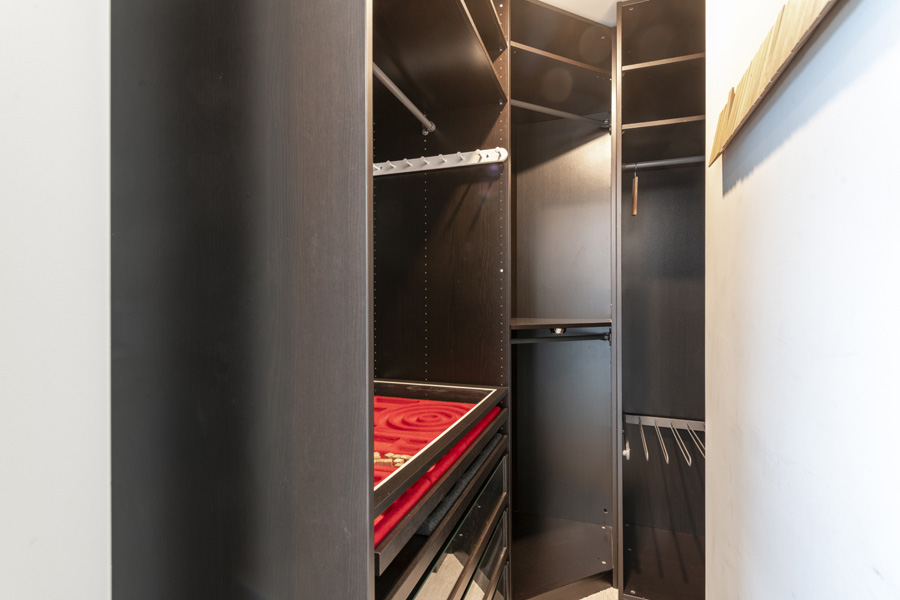 23_walk_in Walk-in closet with custom shelving, hanging storage, and built-in drawers.